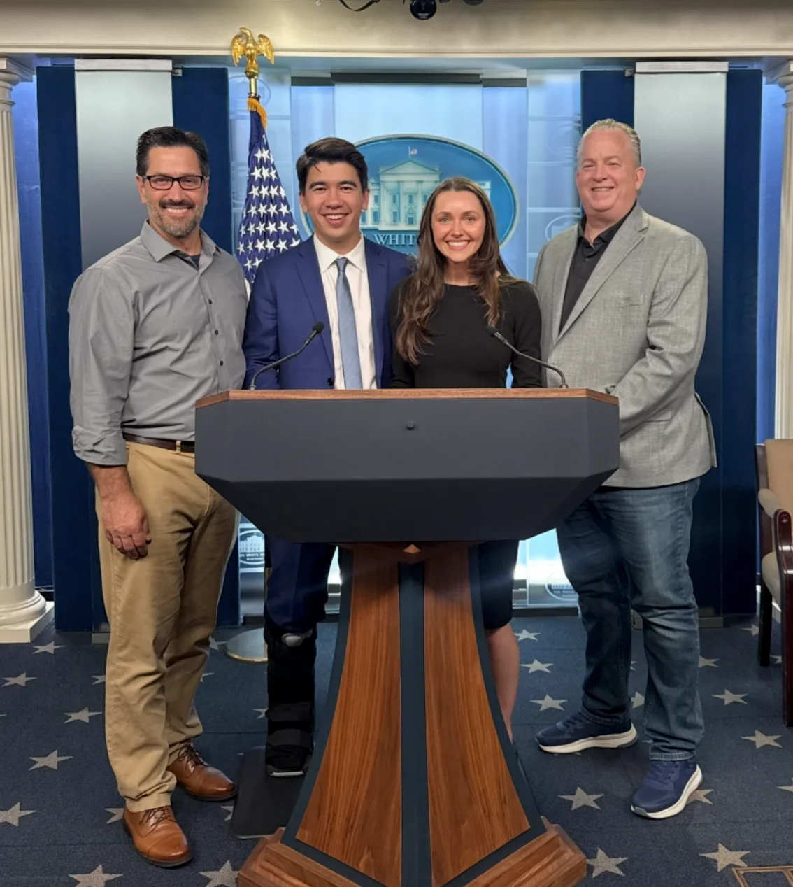 Denton Carlson, Guillaume Delepine, Kaleigh Langnes, and John Chell standing behind the podium in the White House Press Briefing Room